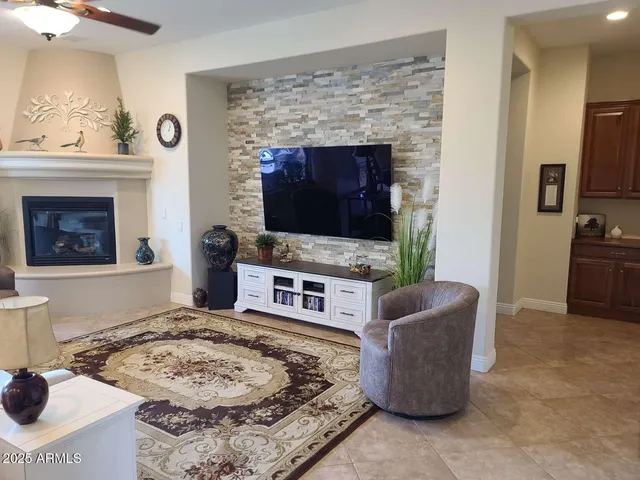 a living room with furniture a flat screen tv and a fireplace
