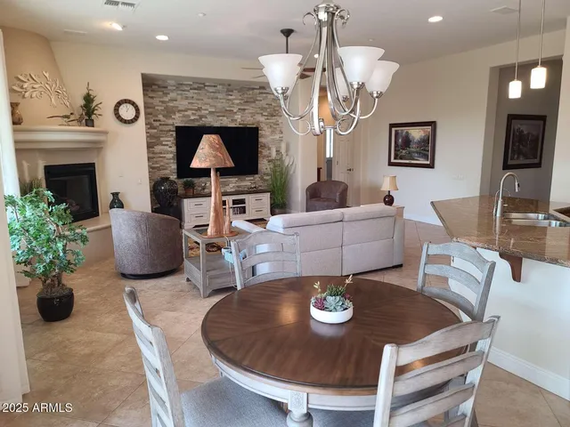 a living room with furniture a chandelier and a fireplace