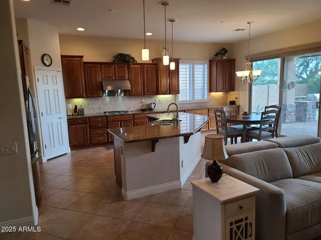 a kitchen with stainless steel appliances granite countertop a sink a stove and a refrigerator
