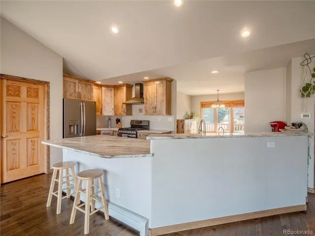 a kitchen with kitchen island a sink stove and refrigerator