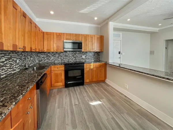 a kitchen with stainless steel appliances granite countertop a stove a sink and a refrigerator