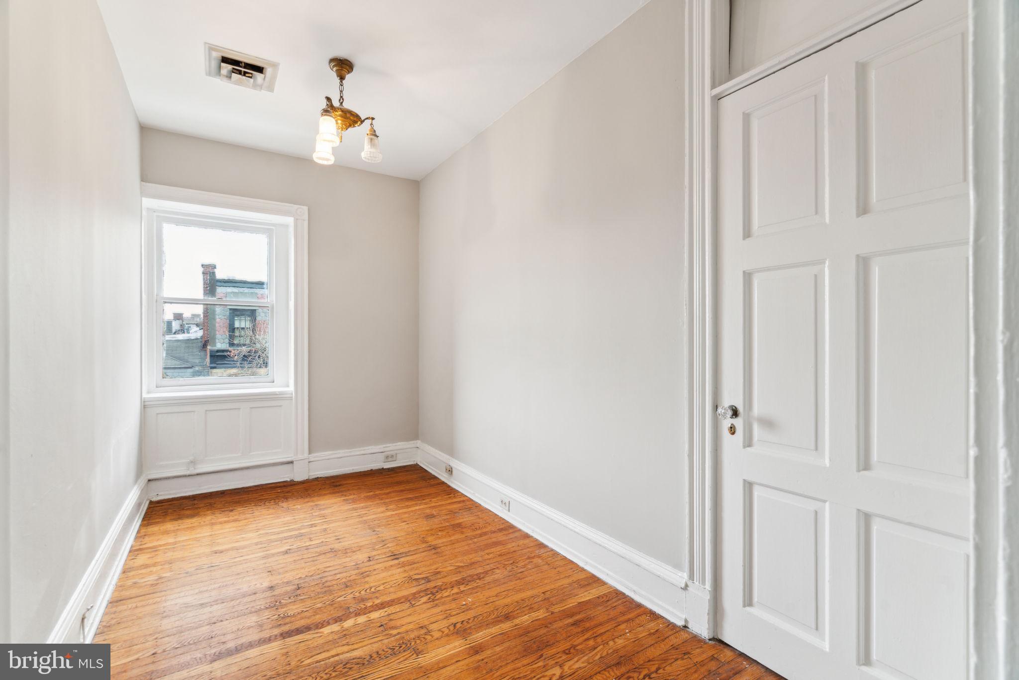 2101 Spruce Street, Unit 4F Philadelphia, PA 19103 - Photo 13 of 24 a view of an empty room with wooden floor and a window
