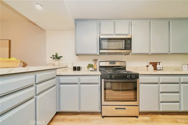 a kitchen with white cabinets and appliances