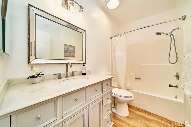 a bathroom with a granite countertop sink a toilet and a bathtub