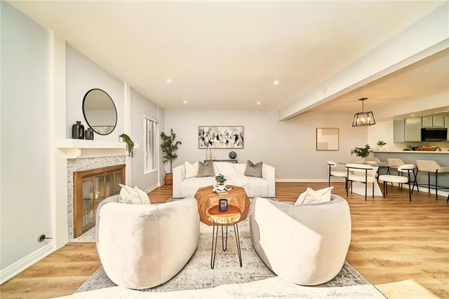 a living room with furniture a fireplace and kitchen view