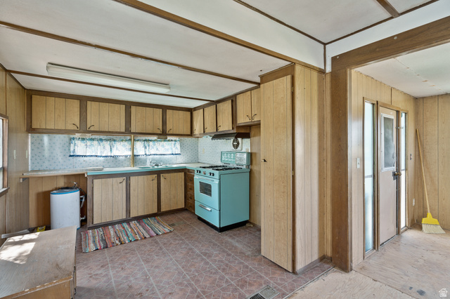 12615 Cedar Ridge Drive, Unit C41 Fairview, UT 84629 - Photo 12 of 32 Kitchen with range with gas stovetop, healthy amount of natural light, wooden walls, backsplash, and light countertops