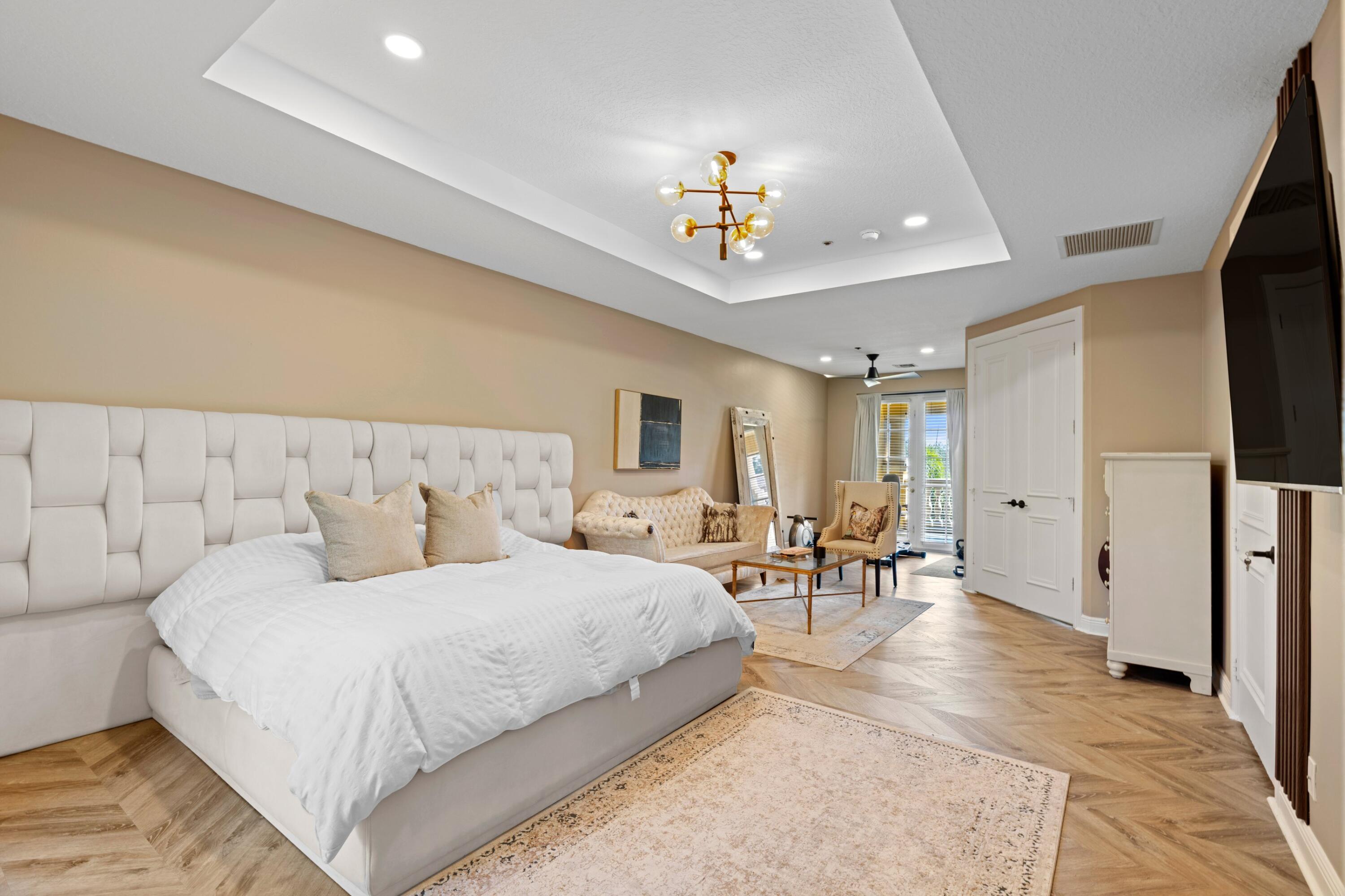 230 Northeast 69th Circle Boca Raton, FL 33487 - Photo 11 of 49 a bedroom with a large bed and a chandelier