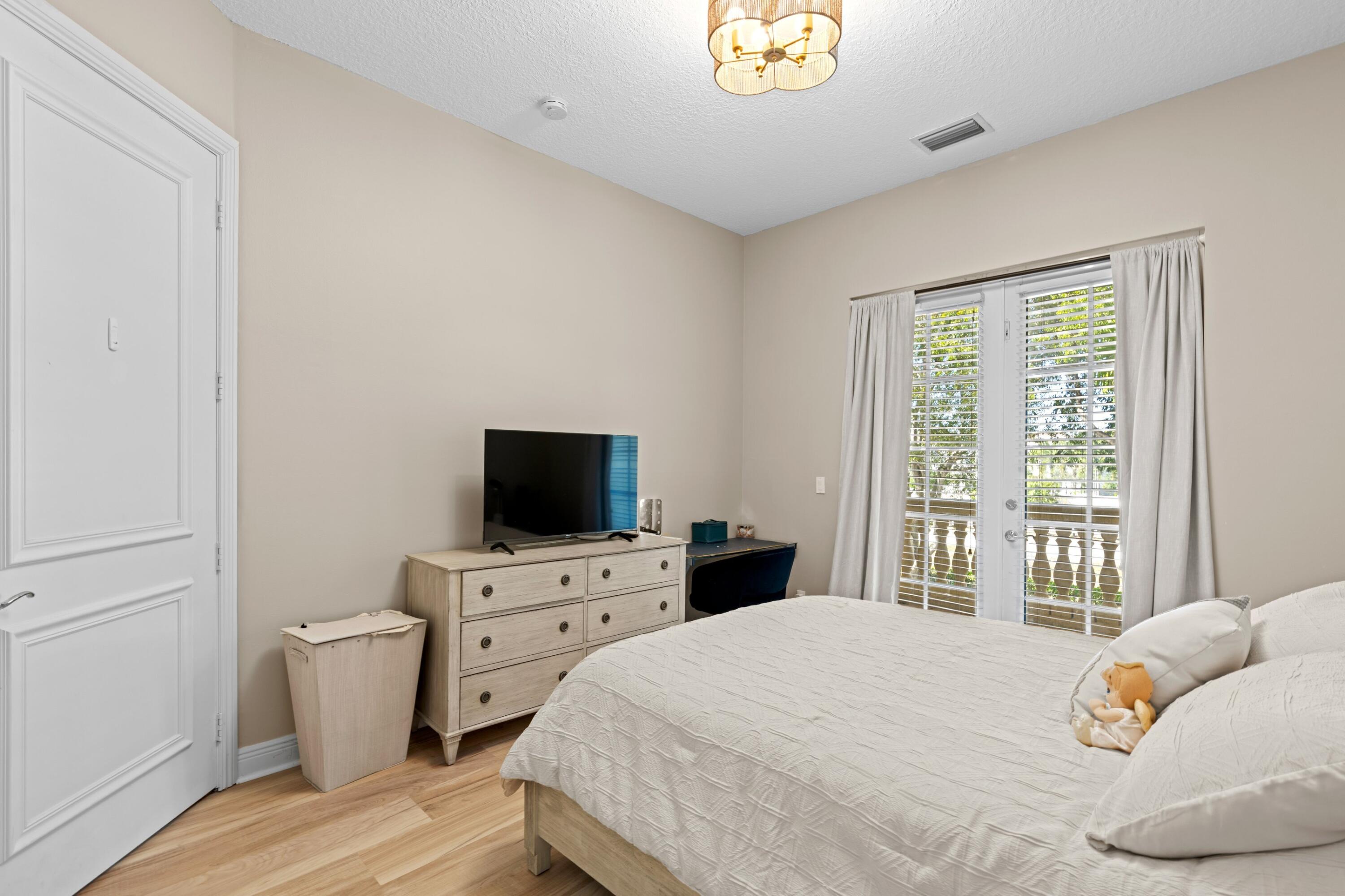 230 Northeast 69th Circle Boca Raton, FL 33487 - Photo 17 of 49 a bedroom with a bed and a flat screen tv