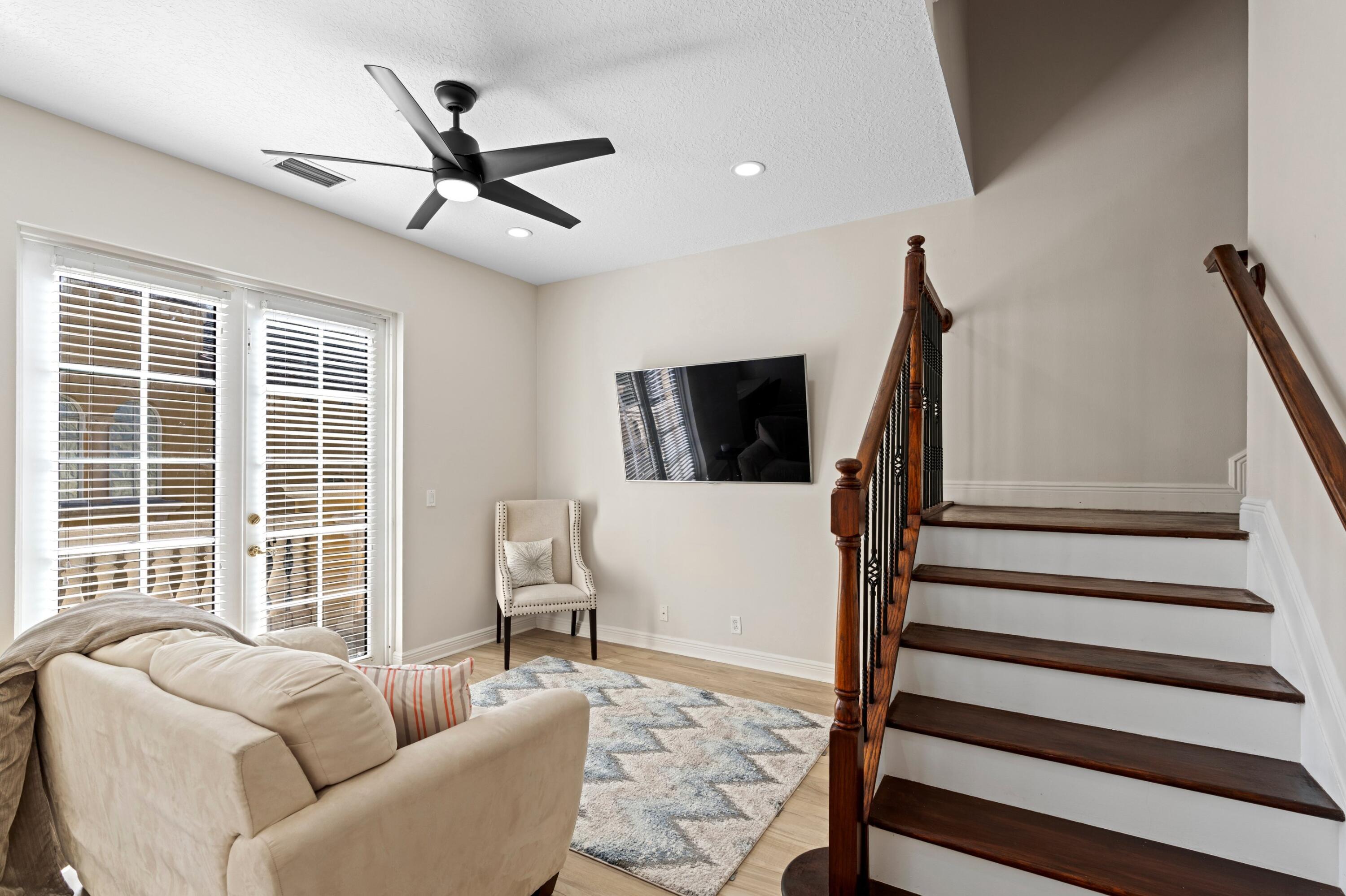 230 Northeast 69th Circle Boca Raton, FL 33487 - Photo 22 of 49 a living room with furniture floor to ceiling window and a flat screen tv