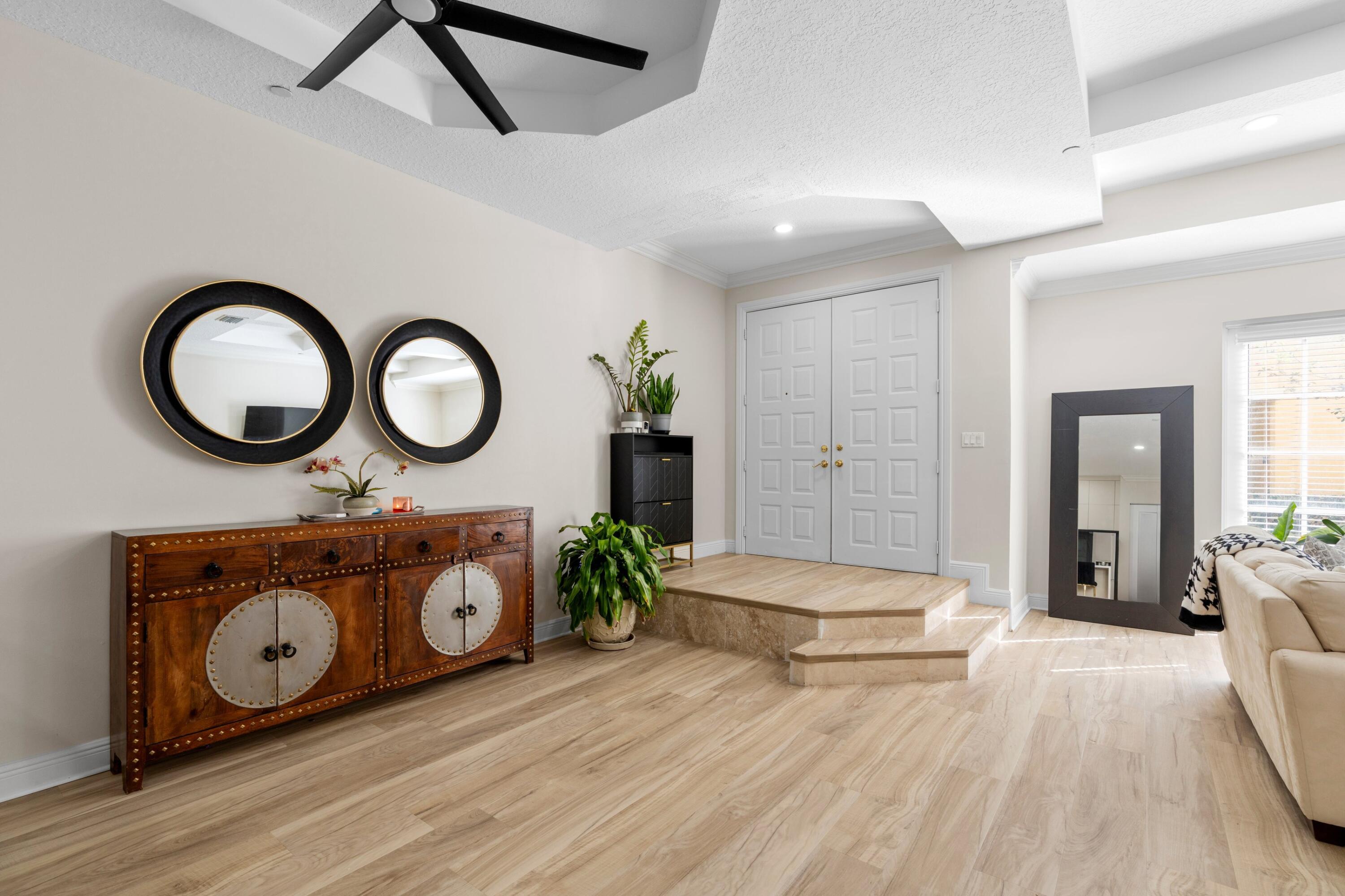 230 Northeast 69th Circle Boca Raton, FL 33487 - Photo 6 of 49 a living room with a mirror and a wooden floor