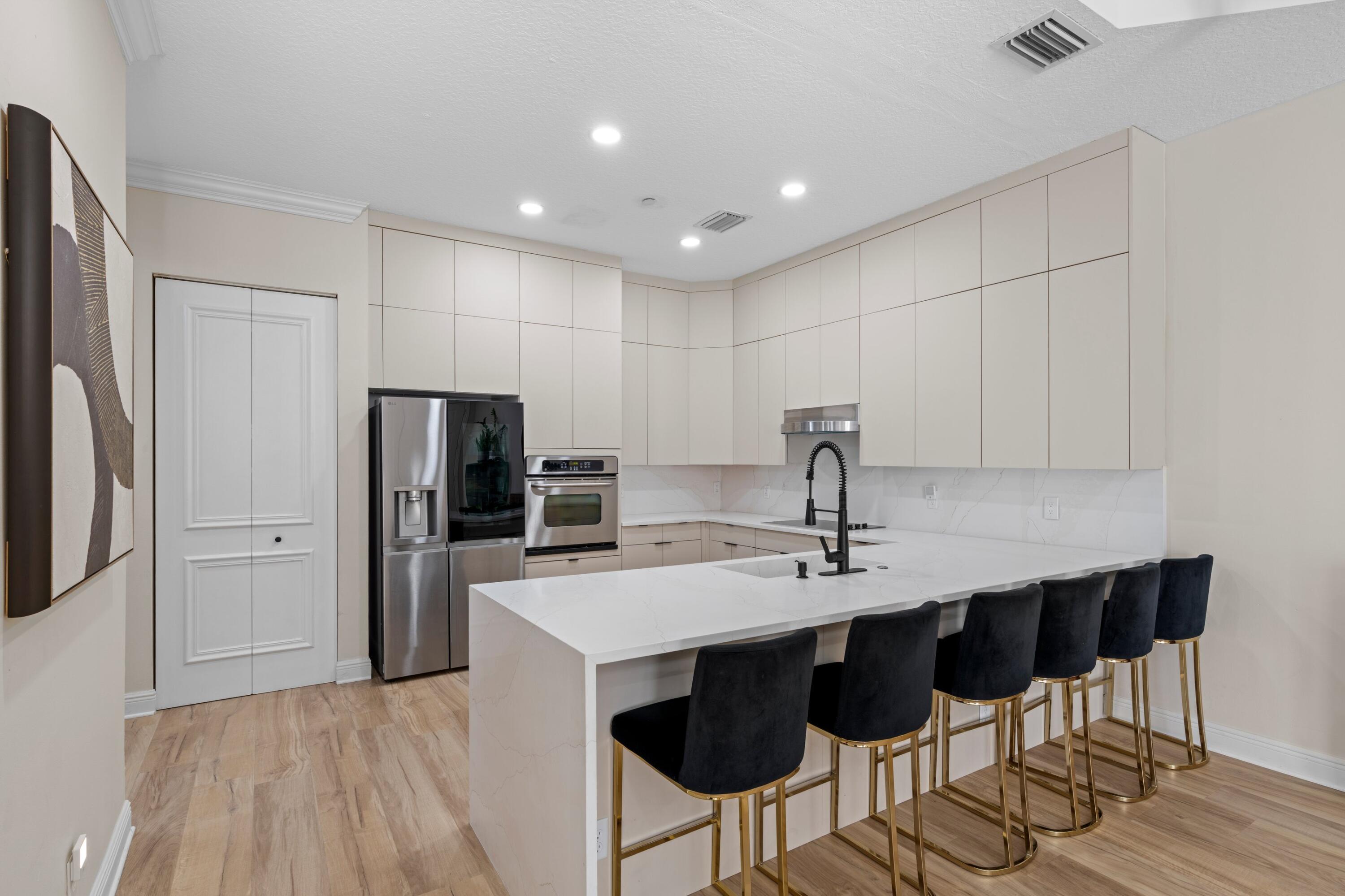 230 Northeast 69th Circle Boca Raton, FL 33487 - Photo 8 of 49 a kitchen with stainless steel appliances a sink cabinets and refrigerator