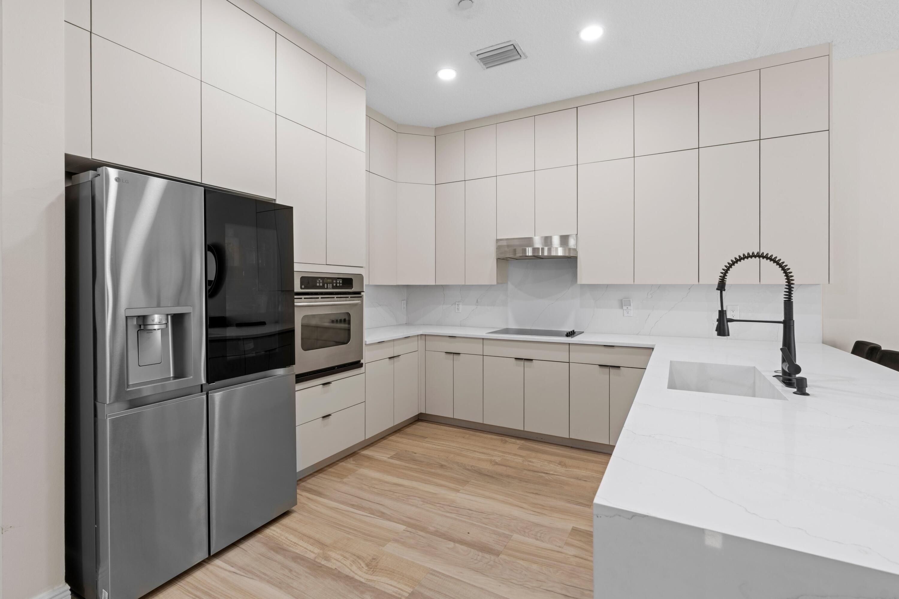 230 Northeast 69th Circle Boca Raton, FL 33487 - Photo 9 of 49 a kitchen with stainless steel appliances a refrigerator sink and cabinets