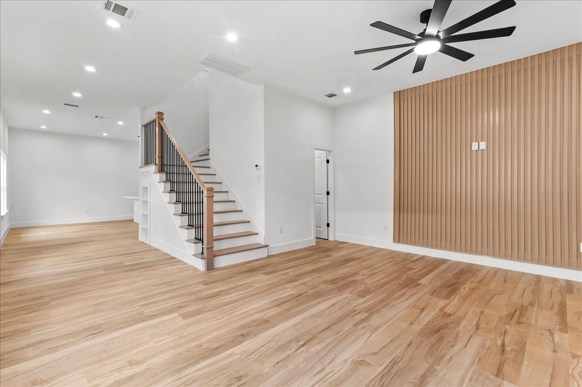 8323 Observatory Street, Unit A/B Houston, TX 77088 - Photo 17 of 38 Unit B - Beautiful custom staircase featuring natural wood treads, sleek black iron balusters, and elegant white wainscoting. A perfect blend of modern design and timeless craftsmanship, creating a stunning focal point in the home. Accent Wall design may vary. Pictures are from a previous build.