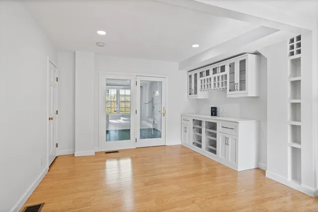 a view of empty room with wooden floor and windows
