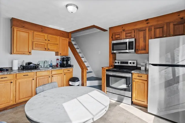 a kitchen with stainless steel appliances a stove a sink and a refrigerator