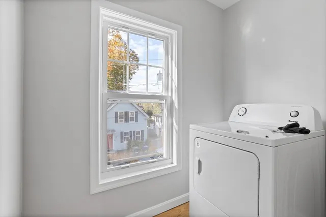 a view of washer and dryer with bathroom in the background