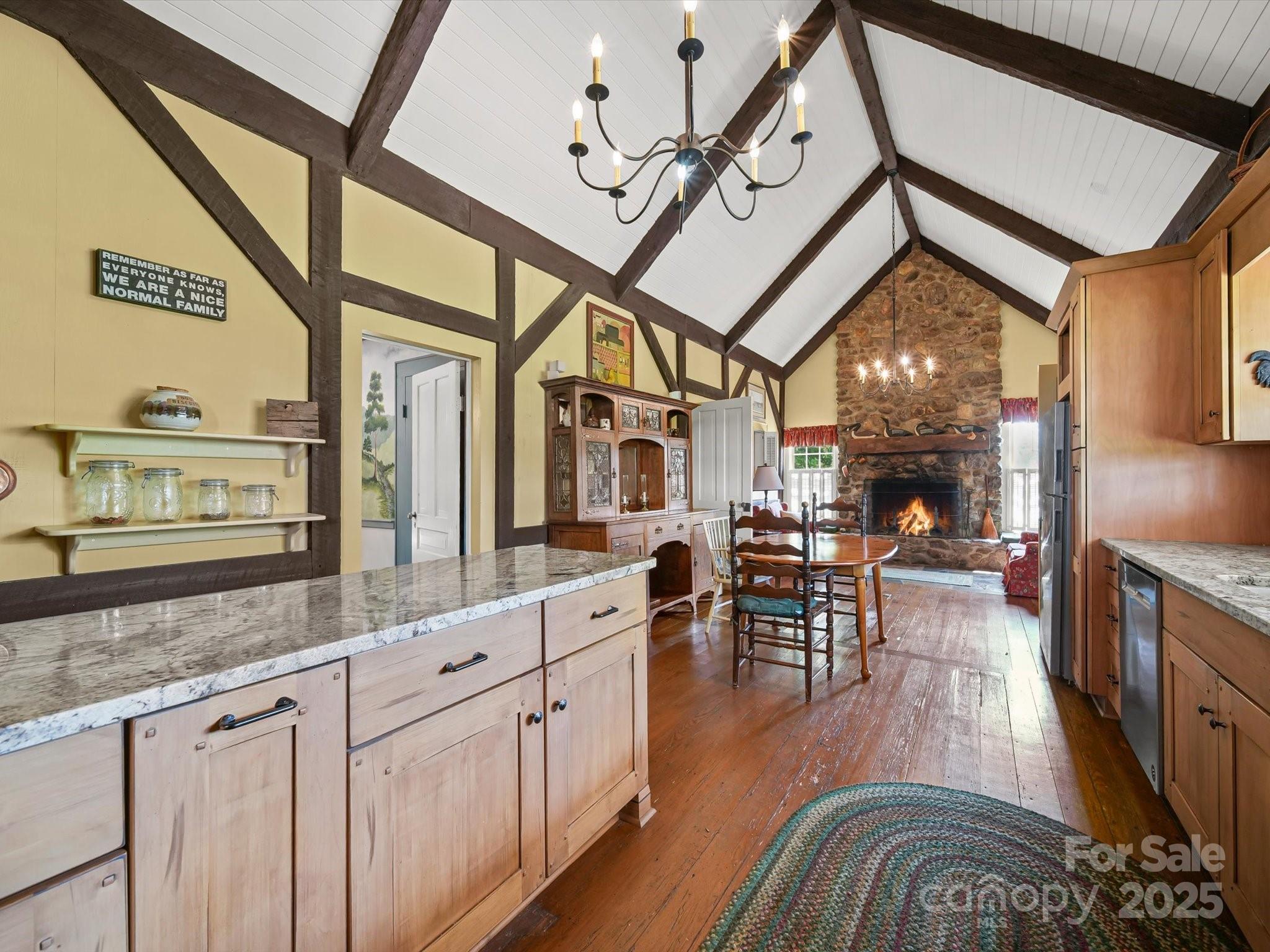 16801 Randalls Ferry Road Norwood, NC 28128 - Photo 19 of 48 a view of a living room and kitchen with furniture wooden floor and a clock