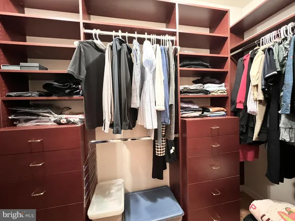 a view of walk in closet with clothes and shoes