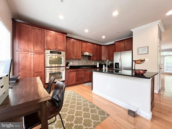 a kitchen with stainless steel appliances granite countertop wooden cabinets a refrigerator a stove a sink and a microwave
