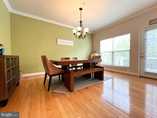 a dining room with furniture a chandelier and wooden floor