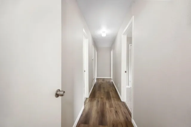 a view of a hallway with wooden floor