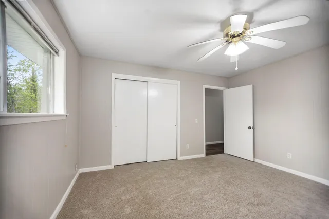 an empty room with fan and windows