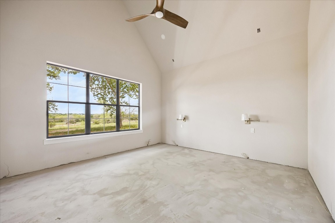 1 Windmill Ridge Brenham, TX 77833 - Photo 12 of 29 Primary bedroom with bedside lamps, vaulted ceiling with beam. Breathtaking view from every room