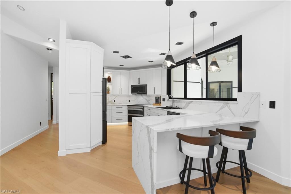 1506 Jewel Naples, FL 34102 - Photo 13 of 49 a kitchen with stainless steel appliances a refrigerator a sink a stove and white cabinets