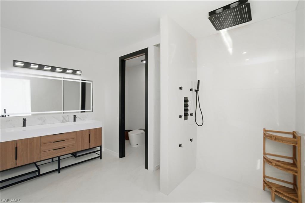 1506 Jewel Naples, FL 34102 - Photo 20 of 49 a bathroom with a double vanity sink a mirror and shower