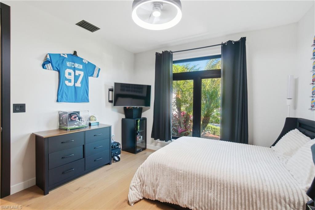 1506 Jewel Naples, FL 34102 - Photo 24 of 49 a bedroom with a bed and a flat tv screen on dresser