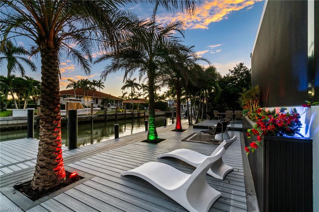 1506 Jewel Naples, FL 34102 - Photo 39 of 49 a view of a patio with table and chairs potted plants and palm tree