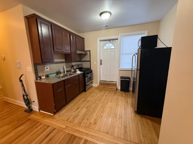 a kitchen with a refrigerator stove and wooden cabinets