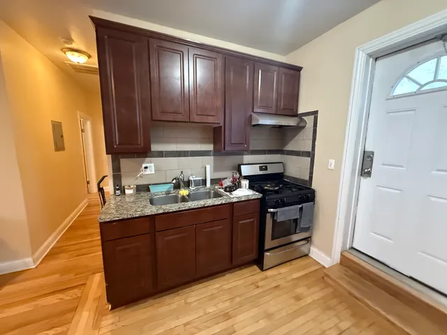 a kitchen with stainless steel appliances granite countertop a stove a sink and a refrigerator