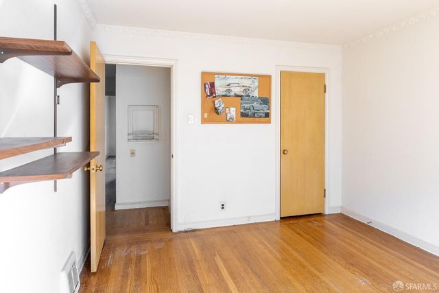 a view of a room with wooden floor and a hallway