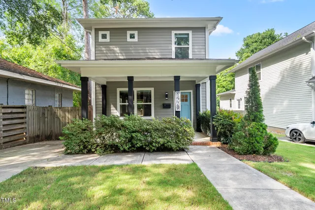 a view of a house with potted plants and a table and chairs