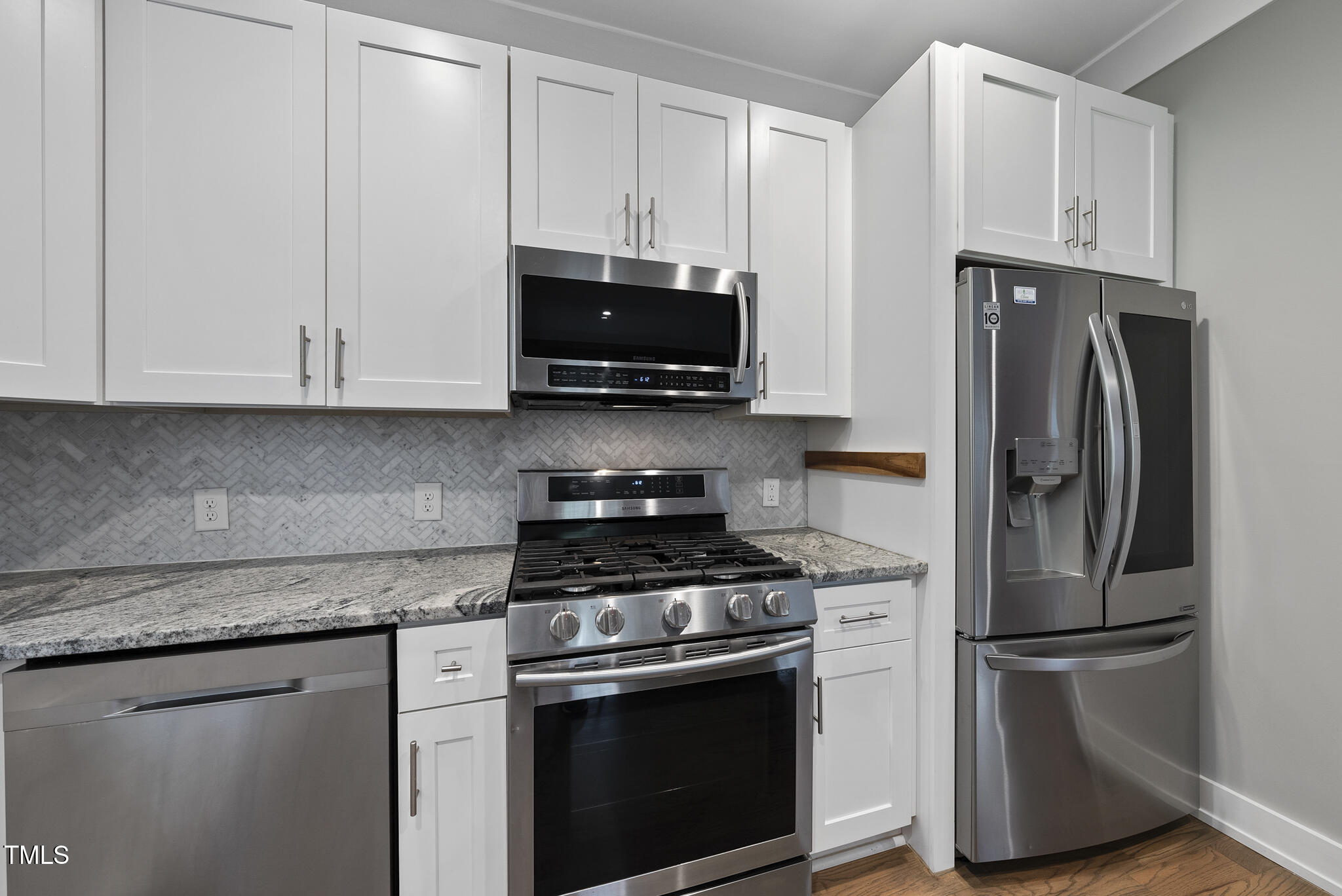 1529 Battery Drive Raleigh, NC 27610 - Photo 11 of 34 a kitchen with cabinets stainless steel appliances and a wooden floor