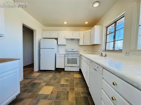 a kitchen with a sink a refrigerator and window