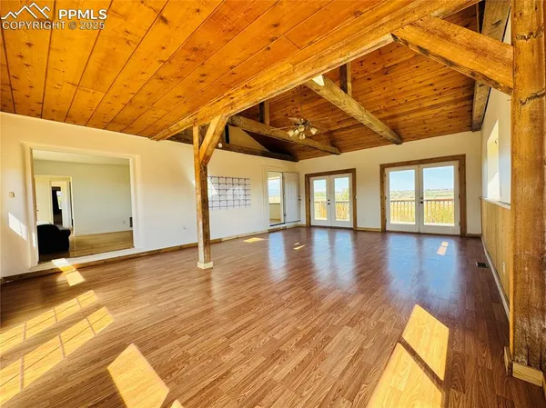 a view of a room with wooden floor and windows