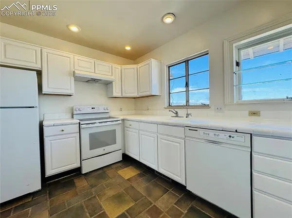 a kitchen with white cabinets appliances and a sink