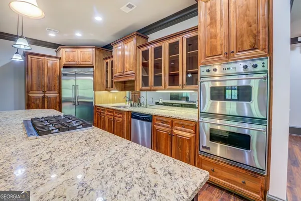 a kitchen with stainless steel appliances granite countertop a stove a sink and a refrigerator