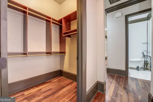 a view of walk in closet with empty racks