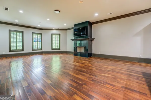 a view of empty room with wooden floor and fireplace
