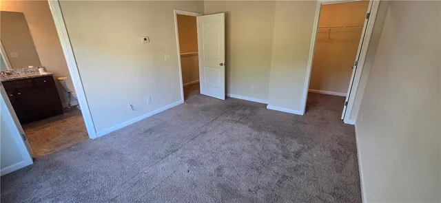 a bathroom with a granite countertop toilet sink and mirror