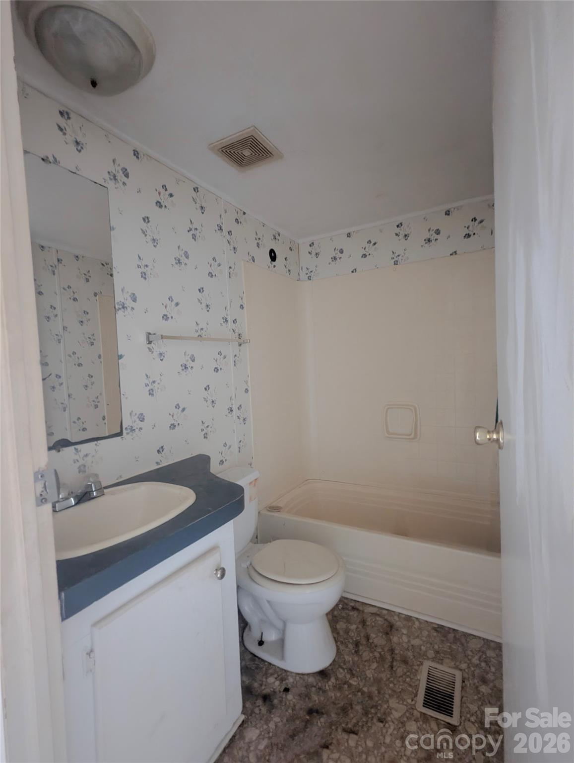 565 Jm Lovelace Road Ellenboro, NC 28040 - Photo 38 of 42 a bathroom with a granite countertop toilet a sink a mirror and shower