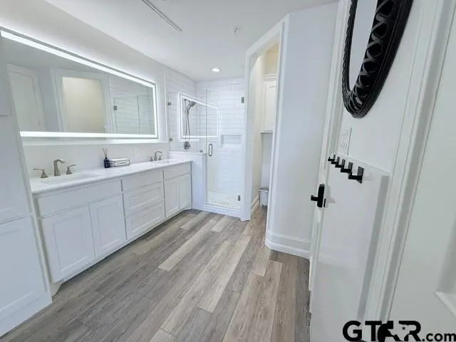a bathroom with a sink and mirror with toilet