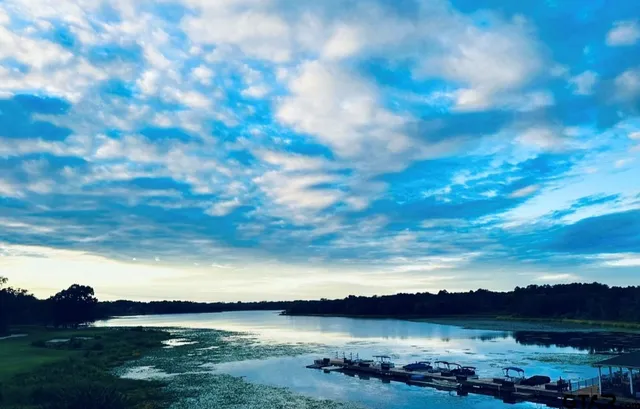 a view of lake with sunset in background