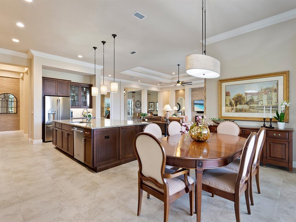 11708 Rive Isle Run Parrish, FL 34219 - Photo 16 of 65 a view of a dining room and livingroom with furniture wooden floor a chandelier