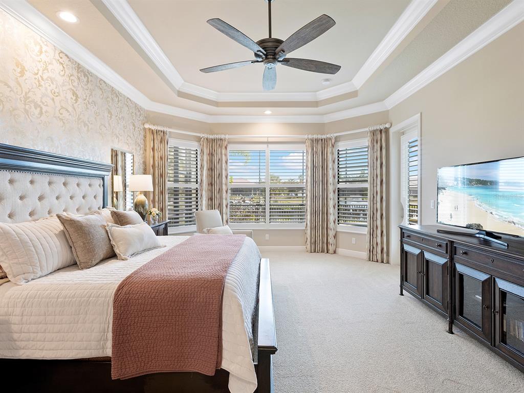 11708 Rive Isle Run Parrish, FL 34219 - Photo 25 of 65 a spacious bedroom with a bed and a flat screen tv