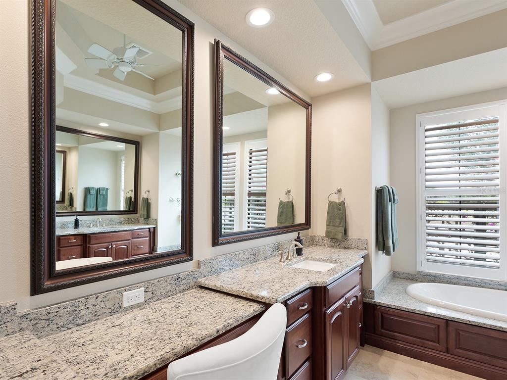 11708 Rive Isle Run Parrish, FL 34219 - Photo 30 of 65 a bathroom with a granite countertop sink and a mirror a bathtub