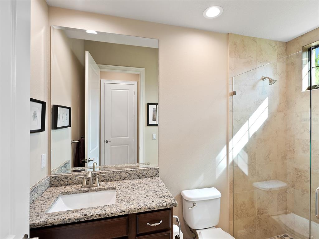 11708 Rive Isle Run Parrish, FL 34219 - Photo 38 of 65 a bathroom with a granite countertop sink and a mirror